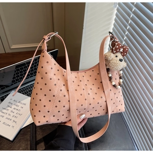 Detail showing pink polka dot hobo bag with a cute plush dog pendant and zipper closure