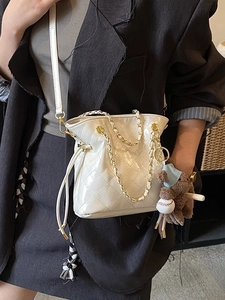 White quilted bucket bag with gold chain strap and cute bear charm for women