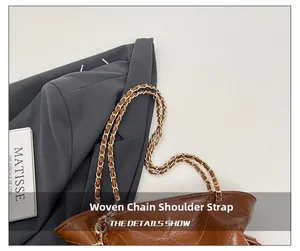 Détail de la bandoulière chaîne tressée sur un sac seau matelassé marron foncé