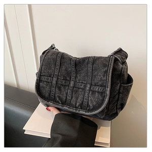 Detail of washed black denim crossbody bag with multi-pocket design and retro stitching