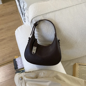 Détail du sac demi-lune en cuir marron foncé avec un fermoir rotatif en métal argenté