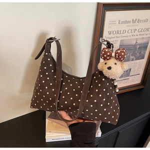 Brown polka dot shoulder bag with cute plush bear charm detail and zipper closure