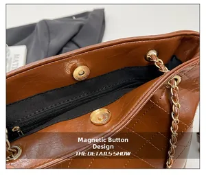 Vue détaillée du fermoir magnétique sur un sac seau en cuir matelassé marron