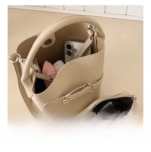 Detail view of cream pebble leather bucket bag interior capacity and matching pouch
