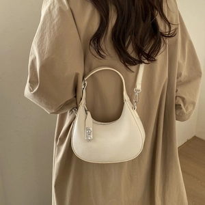 Détail du sac hobo demi-lune beige crème avec texture litchi et fermoir rotatif argenté