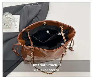 Détail du sac seau matelassé marron avec chaîne dorée et poche intérieure zippée