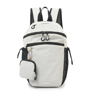 Close-up of beige plaid nylon backpack showing a detachable mini pouch with a silver carabiner