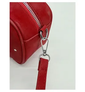 Detail of red pillow bag featuring white star pattern and detachable silver lobster clasp
