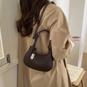 Vue détaillée du sac hobo en cuir grainé marron foncé avec fermoir rotatif argenté porté