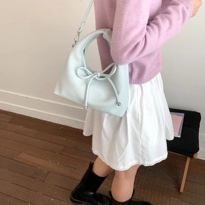 French retro light blue dumpling bag with bow detail and metal ball charm on model