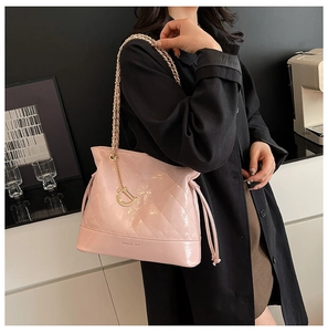 Détail du sac en cuir verni rose matelassé avec chaîne dorée et breloque lettre D