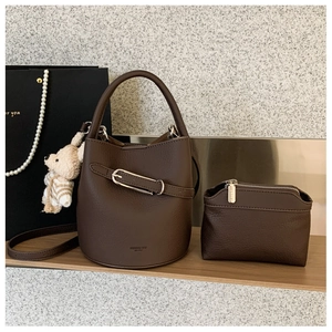 Detail of dark brown lychee grain bucket bag with matching pouch and plush bear charm