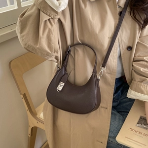 Détail du sac demi-lune marron foncé avec texture cuir litchi et boucle en métal argenté