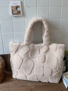 Off-white plush faux fur tote bag with geometric relief pattern for winter fashion