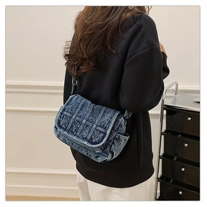 Detail view of vintage blue denim crossbody bag with patchwork design and adjustable strap