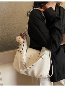 White crescent shoulder bag with plush dog charm and beaded chain accessory for women