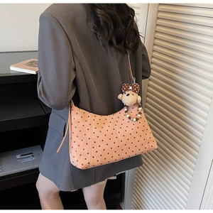 Detail view of peach polka dot shoulder bag with cute teddy bear plush charm