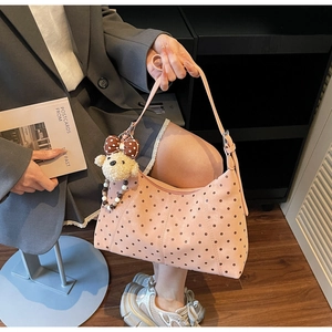 Detailed shot of pink polka dot crescent bag with a cute plush bear charm accessory