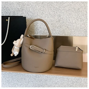 Brown litchi grain bucket bag set with matching pouch on a wooden shelf detail