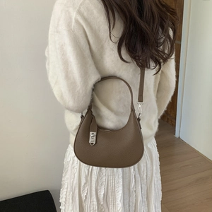 Détail du sac porté épaule marron en cuir grainé avec fermoir argenté et bandoulière fine