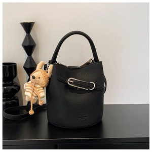 Detail of black lychee grain leather bucket bag with metal buckle and rabbit charm