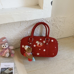 Detail of red canvas pillow bag with white stars and plush rocking horse pendant