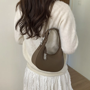 Détail d'un sac demi-lune en cuir marron grainé avec boucle argentée et bandoulière