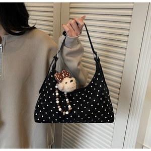 Detail of polka dot underarm bag with a cute plush bear charm and beaded strap