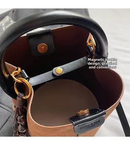 Detailed macro view of brown suede bucket bag featuring magnetic closure and gold hardware
