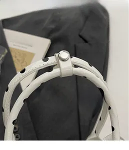 Detail of silver hardware snap button on polka dot handbag with leather texture