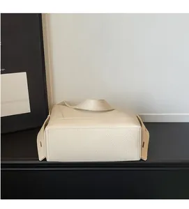 Détail de la texture grainée et de la base solide de ce sac seau de couleur blanc cassé