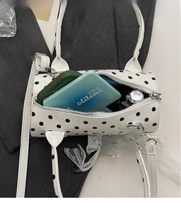 Close-up of polka dot cylinder bag interior showing spacious storage for cosmetics