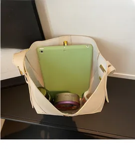 Intérieur spacieux du sac seau en cuir beige montrant la capacité pour iPad et objets