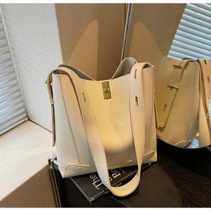 Détail de la texture cuir grainé et du fermoir rotatif en métal doré de ce sac à main chic