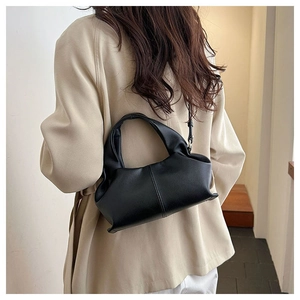 Model wearing a black soft leather cloud bag showing crossbody drape and sleek texture