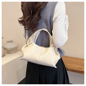 Chic beige dumpling handbag with pleated leather texture shown in a social lifestyle setting