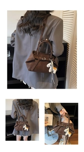 Detalle del bolso de mano vintage marrón oscuro en ante con un lindo colgante de pony blanco