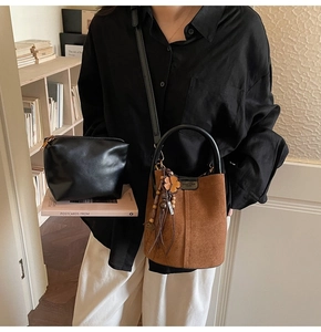 Brown frosted bucket bag with four-leaf clover charm and matching black pouch