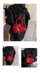 Detalle de bolso rojo mate con hebilla icónica y colgante de caballo pequeño
