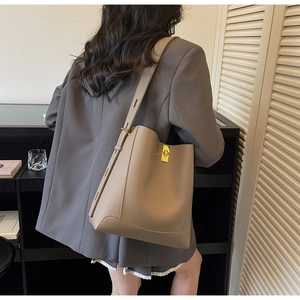 Détail du sac seau kaki montrant le cuir grainé litchi et le fermoir métallique doré