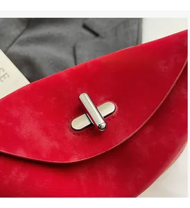 Detailed close-up of premium red suede handbag featuring a polished silver metal twist lock