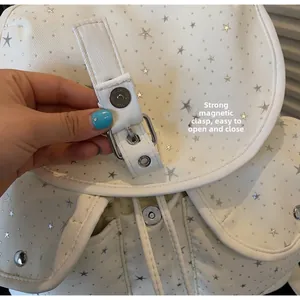 Detail view of the strong magnetic buckle on a white canvas star backpack closure