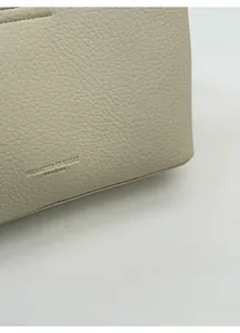 Macro shot of high-quality lychee grain leather texture with embossed fashion branding