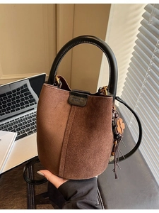 Vintage brown suede bucket bag with black leather handle and wooden flower charm