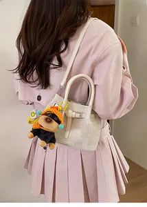 Chic cream-white textured bucket bag with metal buckle and cute dog charm detail