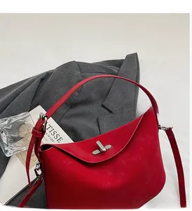 Detail of red minimalist bucket bag featuring a silver twist lock and premium matte texture