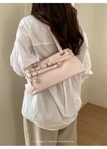 Détail du sac rétro rose avec pendentifs en forme de cœur et bandoulière réglable
