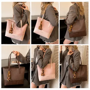 Detail van roze en bruine grote draagtassen met reliëfleer en kraalvormige bedels
