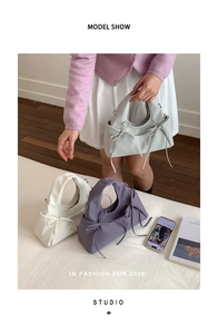 Dettaglio di eleganti borse con fiocco in morbida pelle, colori grigio bianco e viola