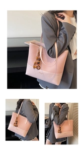 Detailopname van roze shopper met kleurblokken en decoratieve houten kralen accessoire
